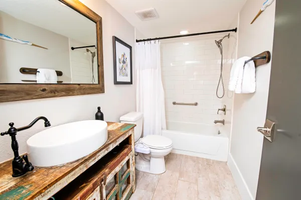 a bathroom with a sink a toilet and shower