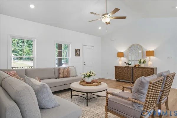 a living room with furniture a rug and a mirror