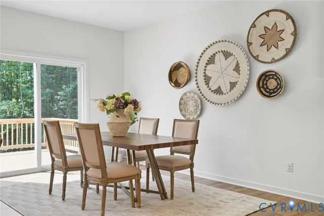 a view of a dining room and livingroom with furniture wooden floor a rug a fireplace