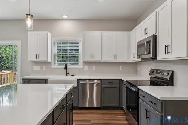 a room with a chandelier fan and wooden floor