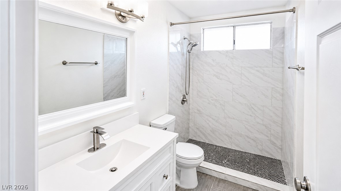 2870 South Sandhill Road Las Vegas, NV 89121 - Photo 49 of 64 White vanity with a large mirror and sleek fixtures create a clean, minimalist bathroom.