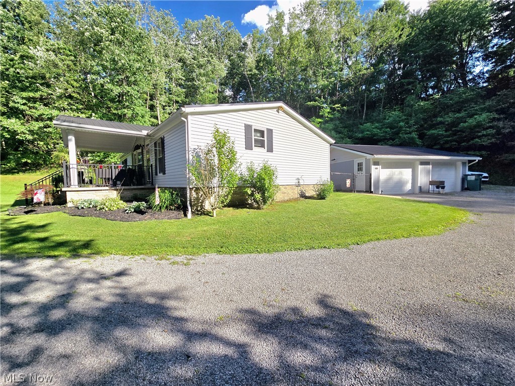 17015 McIntosh Road Wellsville, OH 43968 - Photo 19 of 24 Gravel driveway offering abundant parking, multiple garage buildings, and beautiful wooded surroundings.