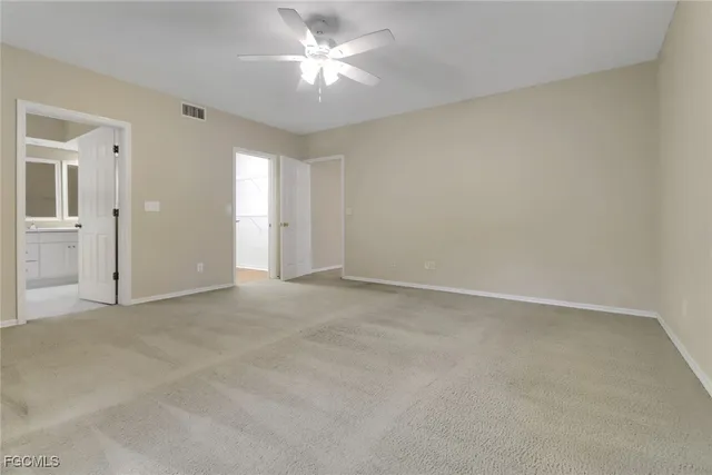 an empty room with a ceiling fan and a window