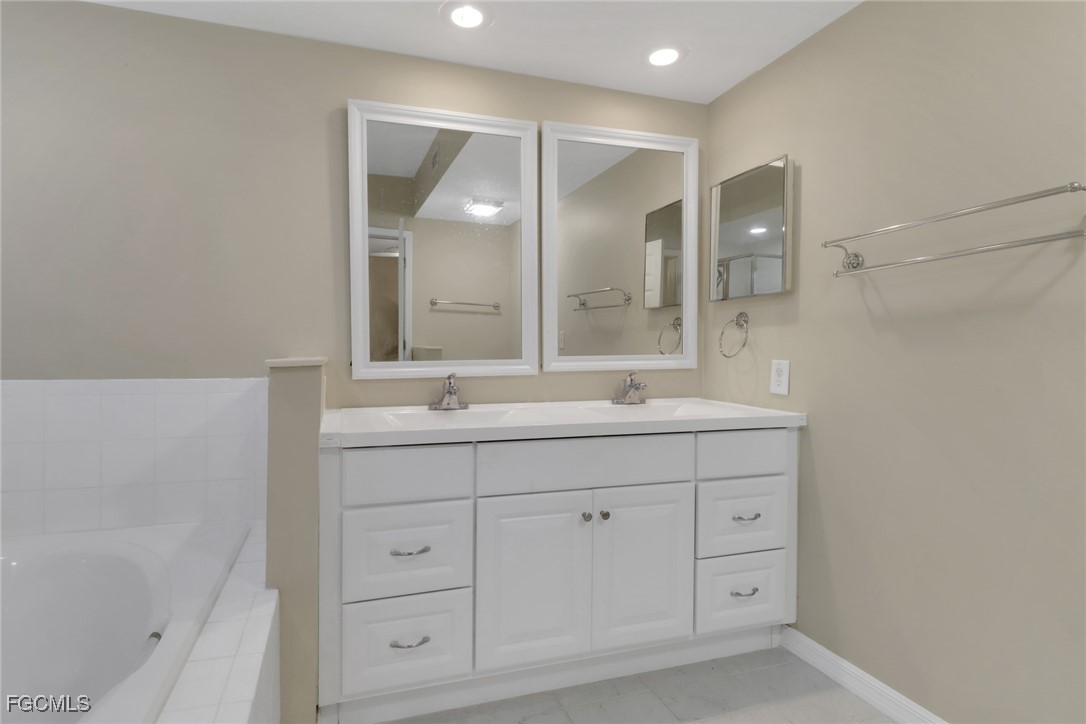 100 Siena Way, Unit 1201 Naples, FL 34119 - Photo 14 of 25 a bathroom with a double vanity sink mirror and double