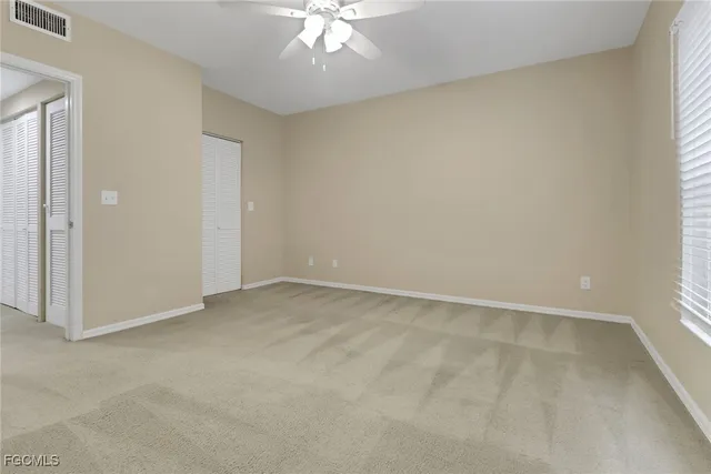 an empty room with a chandelier fan