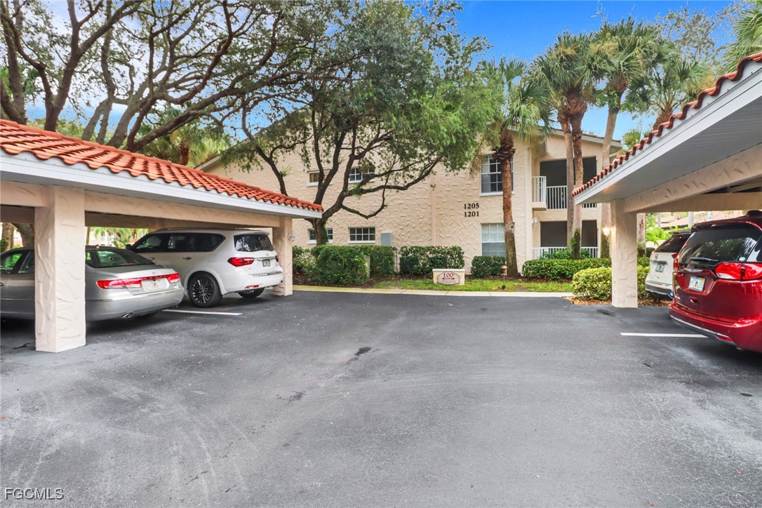 100 Siena Way, Unit 1201 Naples, FL 34119 - Photo 2 of 25 a view of a cars park in front of a building