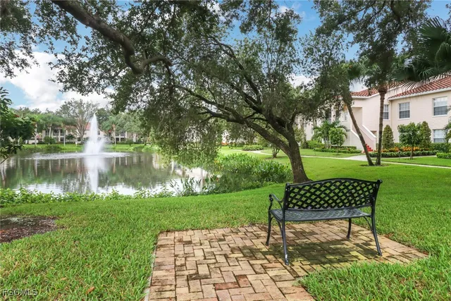 a view of a bench in the garden near a lake