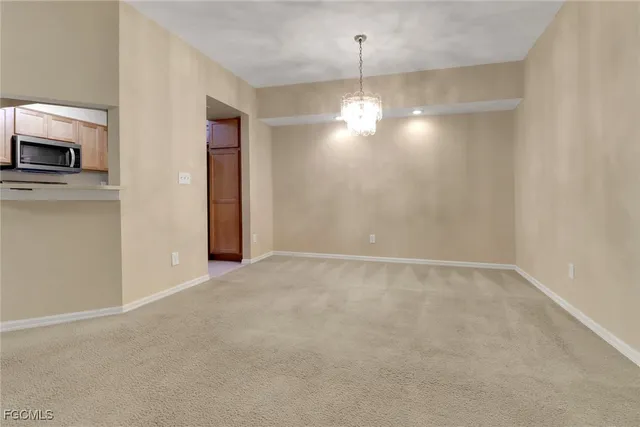 a view of empty room with kitchen and sink