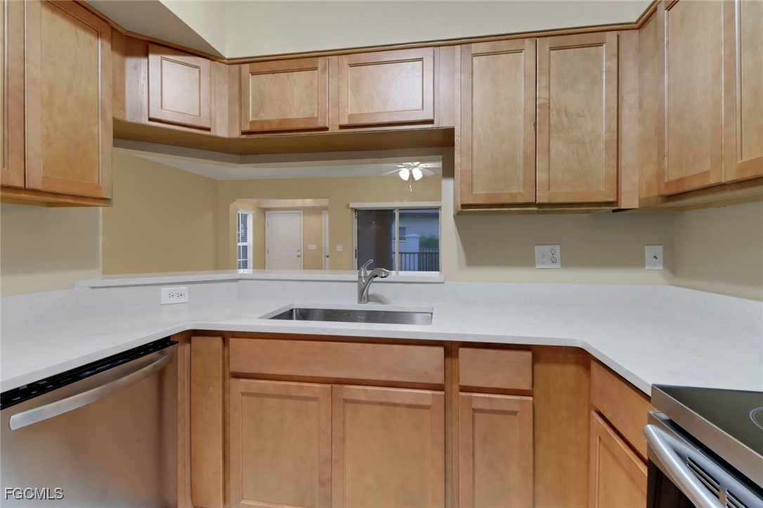 100 Siena Way, Unit 1201 Naples, FL 34119 - Photo 9 of 25 a kitchen with a sink and cabinets