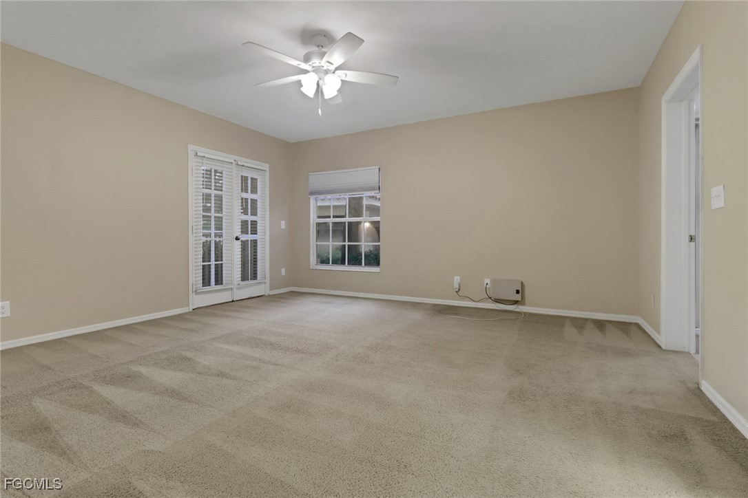 100 Siena Way, Unit 1201 Naples, FL 34119 - Photo 10 of 25 an empty room with chandelier fan and windows