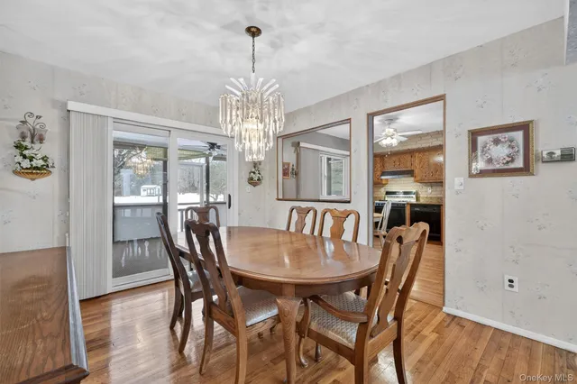 a view of a dining room with furniture a chandelier and wooden floor