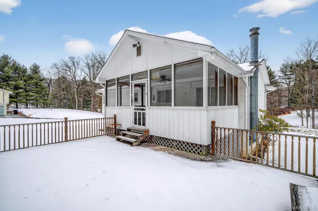 a view of a house with wooden fence and floor to ceiling window