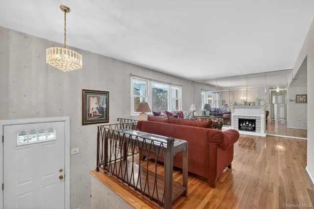 a view of a livingroom with furniture wooden floor windows and a chandelier