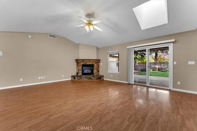 a view of an empty room with a window and a kitchen