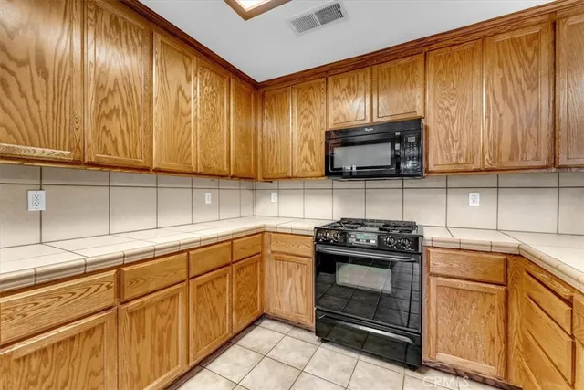 a kitchen with stainless steel appliances granite countertop a refrigerator stove and microwave