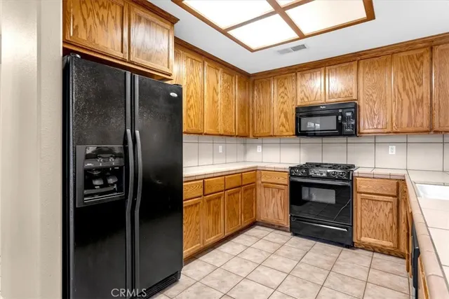 a view of an empty room with window and chandelier
