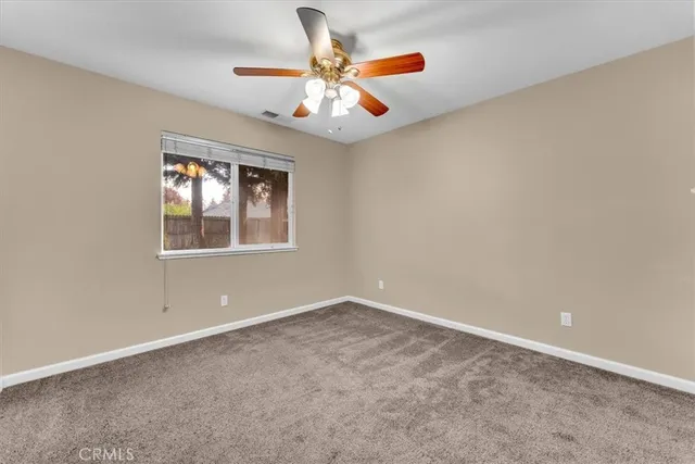 an empty room with closet and a chandelier fan
