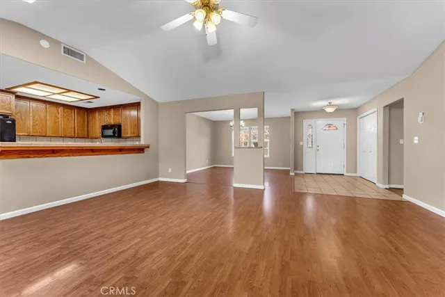 a view of an empty room with a fireplace and wooden floor