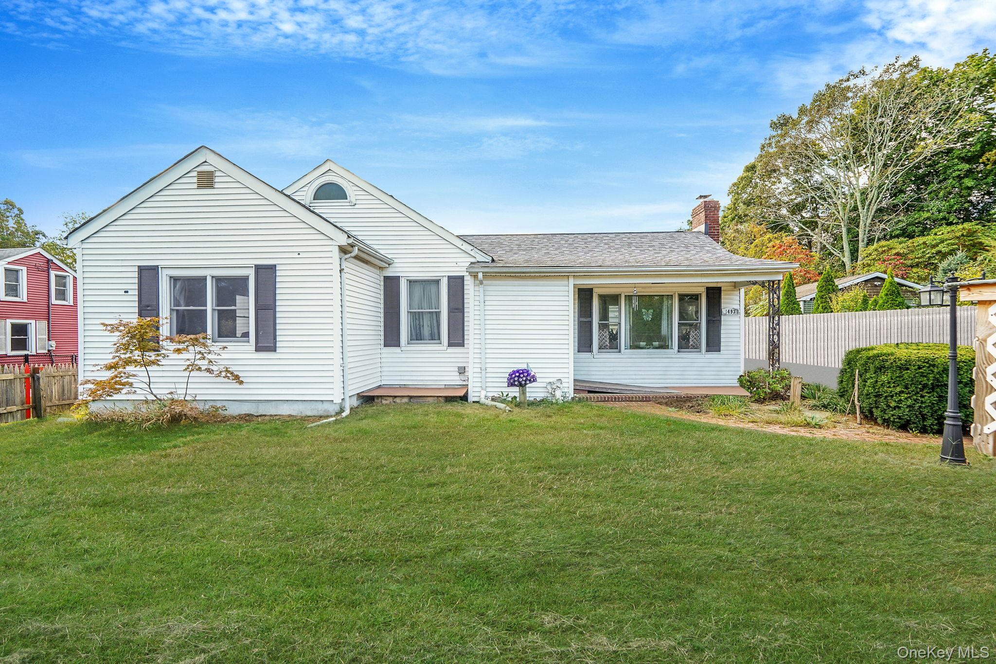 View of front facade featuring a chimney and a shingled roof