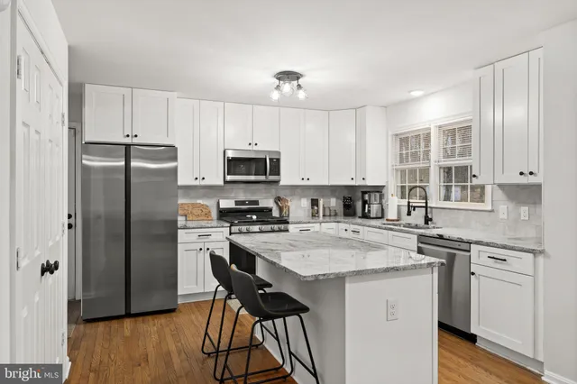 a kitchen with a refrigerator a stove a sink and cabinets