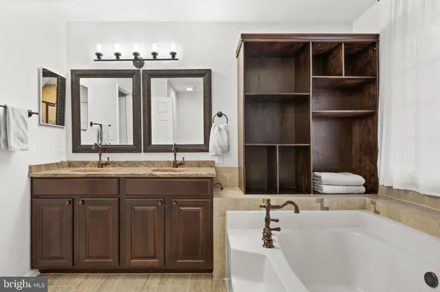 a bathroom with a granite countertop sink a toilet and a large mirror