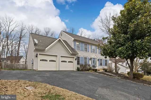 a view of a white house next to a road and yard