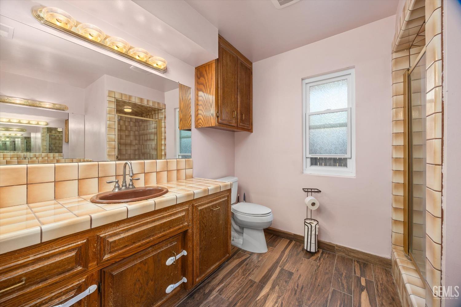 Undisclosed Address Bakersfield, CA 93308 - Photo 15 of 33 a bathroom with a sink a toilet a mirror and shower