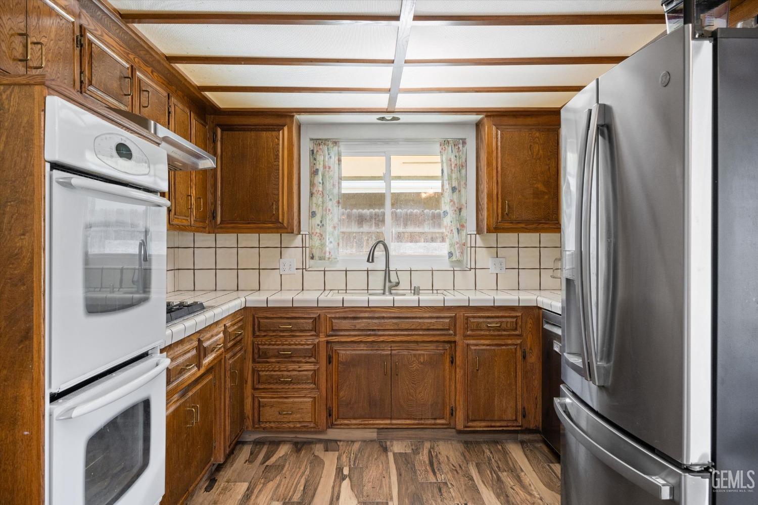 Undisclosed Address Bakersfield, CA 93308 - Photo 10 of 33 a kitchen with stainless steel appliances a sink cabinets and wooden floor