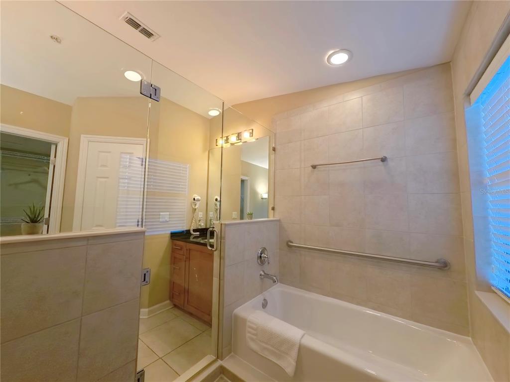 14525 Damai Lane Orlando, FL 32821 - Photo 15 of 30 a bathroom with a bathtub and a shower