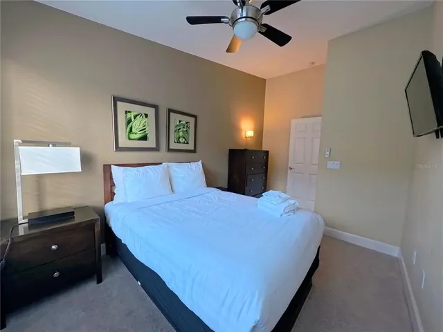 a bedroom with a bed and a flat tv screen on dresser