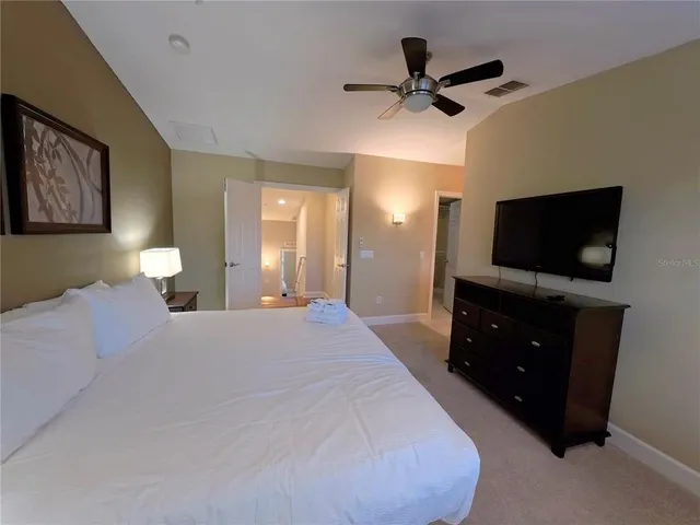 a bedroom with a bed and a flat tv screen on a dresser