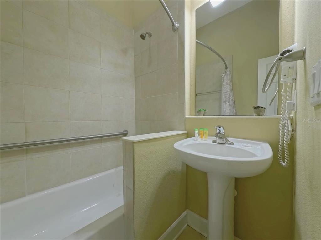 14525 Damai Lane Orlando, FL 32821 - Photo 21 of 30 a bathroom with a sink a shower and a mirror