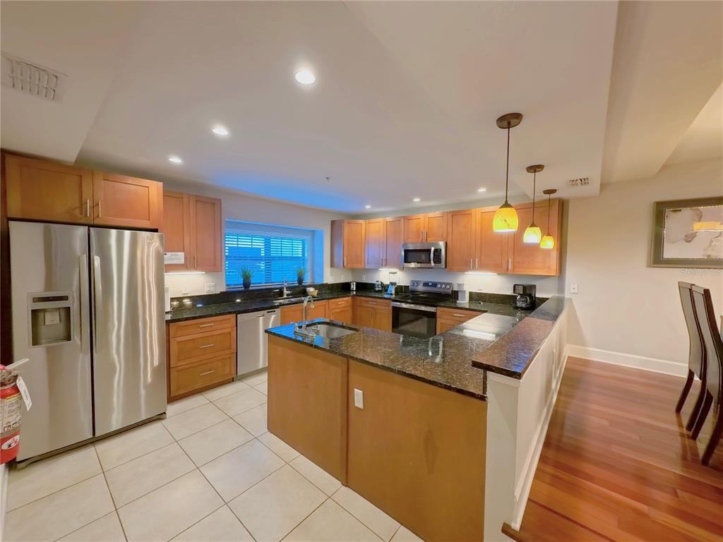 14525 Damai Lane Orlando, FL 32821 - Photo 3 of 30 a kitchen with stainless steel appliances granite countertop a refrigerator a sink a stove and a refrigerator