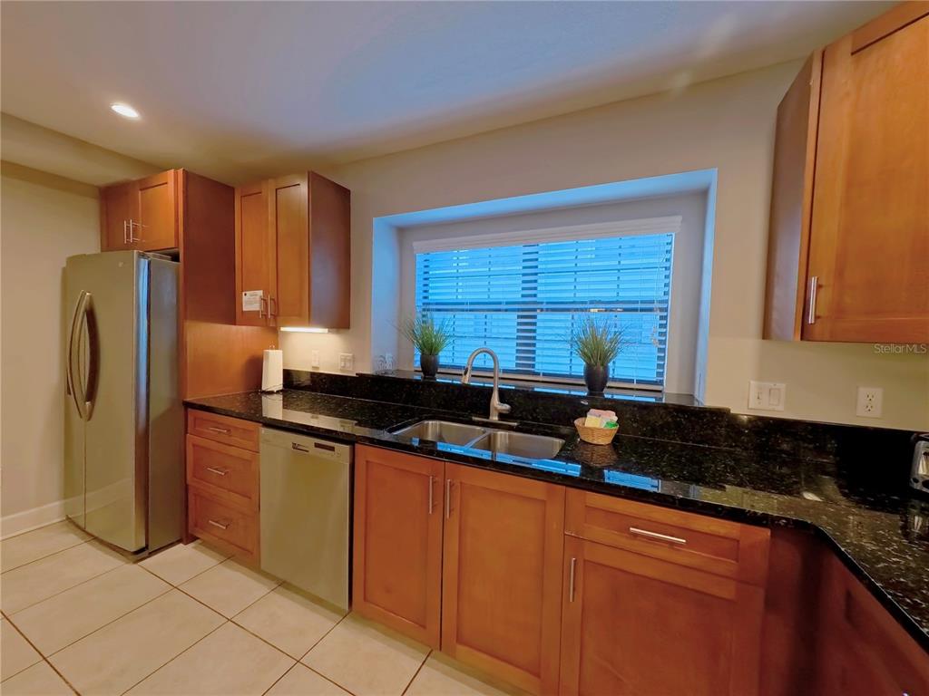 14525 Damai Lane Orlando, FL 32821 - Photo 4 of 30 a kitchen with stainless steel appliances granite countertop a sink and a refrigerator