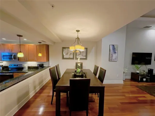 a dining room with furniture a chandelier and wooden floor