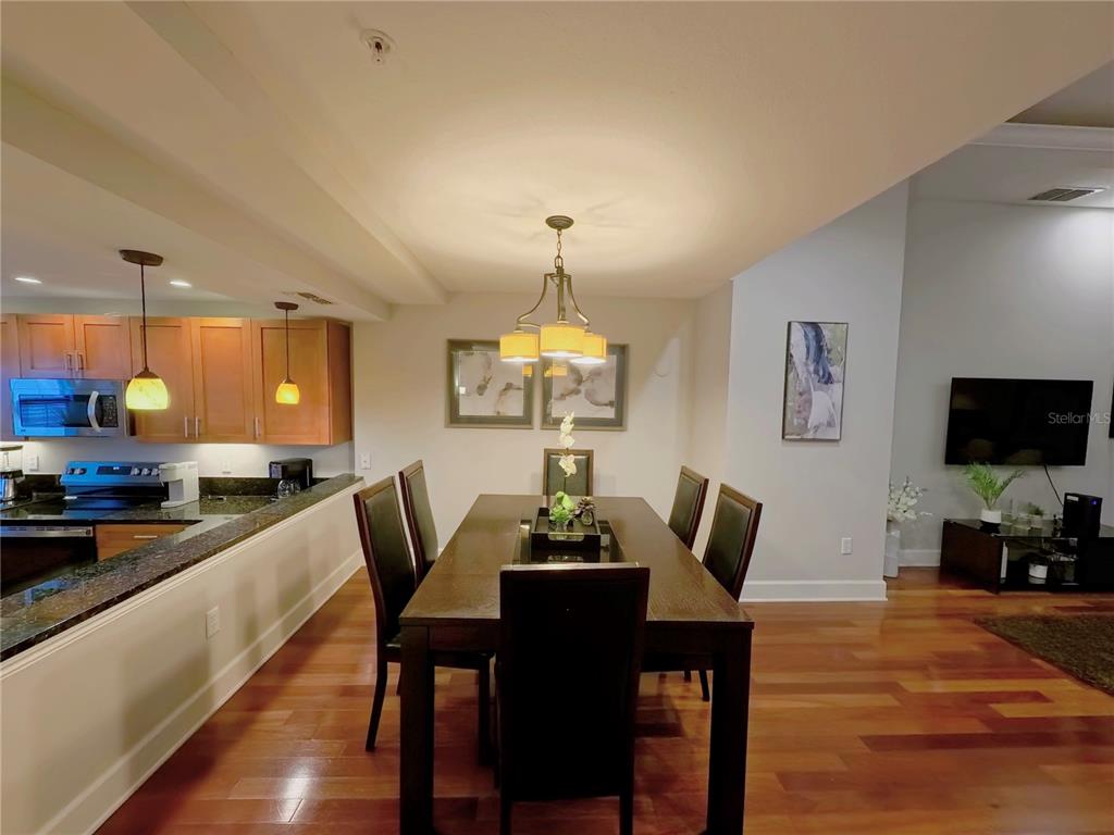 14525 Damai Lane Orlando, FL 32821 - Photo 7 of 30 a dining room with furniture a chandelier and wooden floor