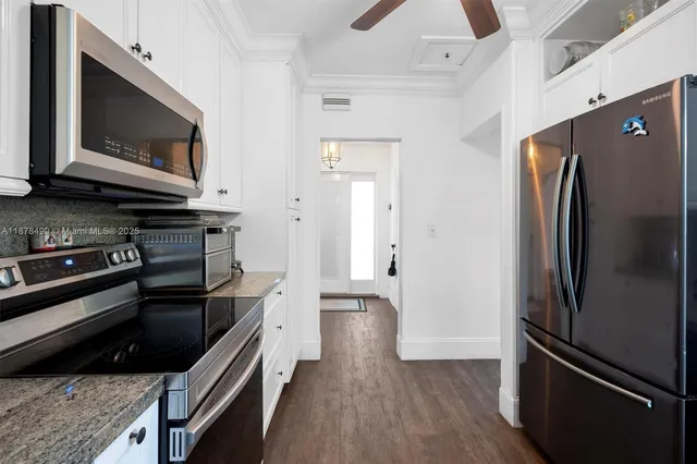 a kitchen with stainless steel appliances and wooden floor