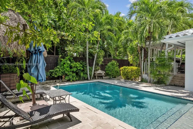 a view of backyard with table and chairs and potted plants