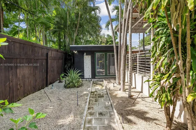 a view of backyard with potted plants and a large tree
