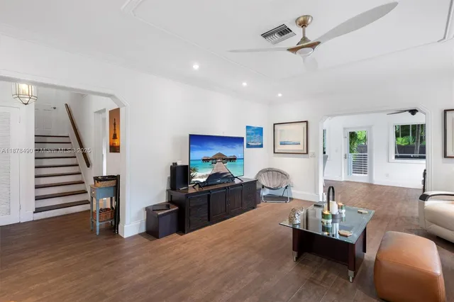 a living room with furniture and a wooden floor