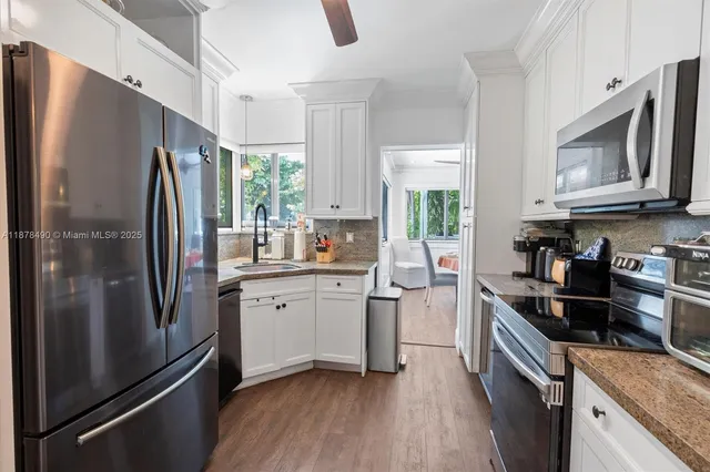 a kitchen with stainless steel appliances a refrigerator sink and microwave