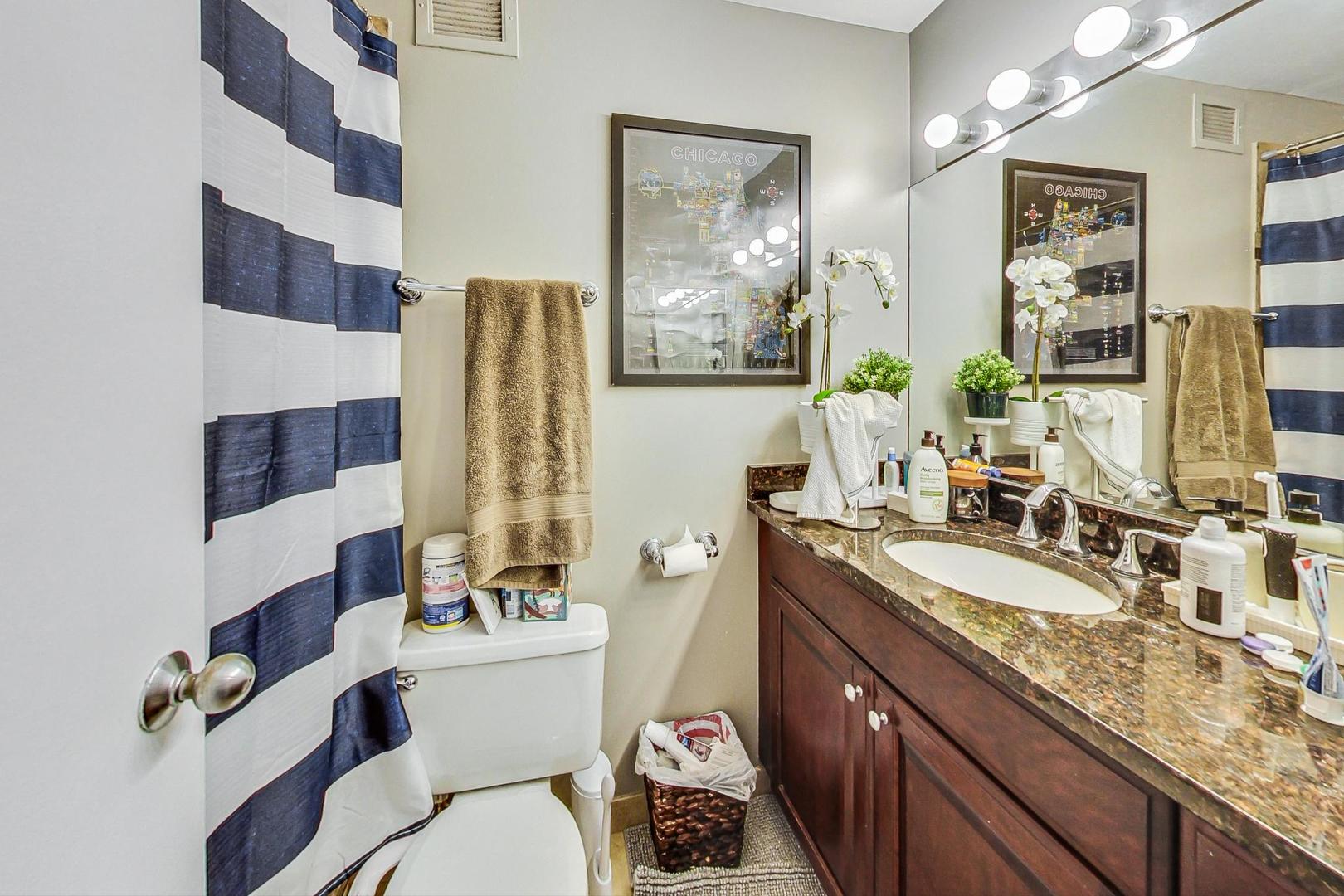 Undisclosed Address Chicago, IL 60601 - Photo 14 of 22 a bathroom with a granite countertop sink mirror vanity and toilet