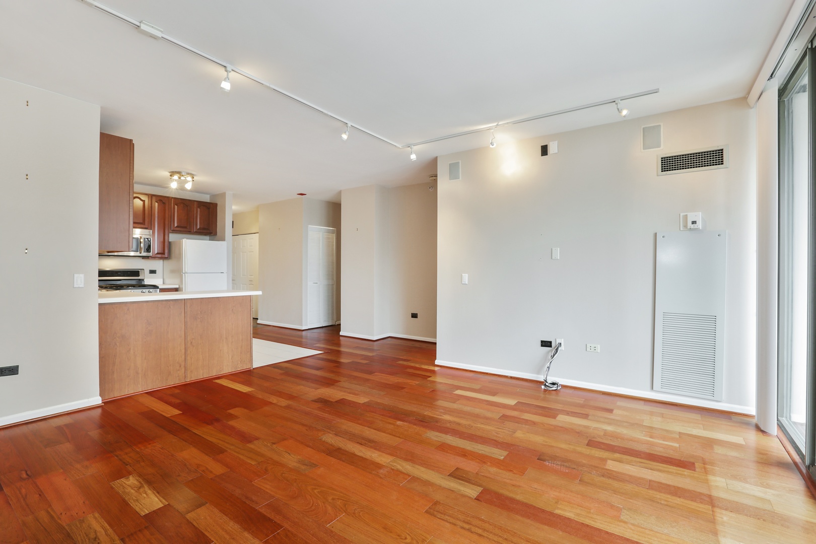 630 North State Street, Unit 1609 Chicago, IL 60654 - Photo 10 of 22 a view of empty room with wooden floor and kitchen view