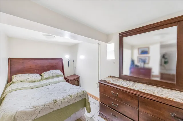 a bedroom with a large bed and a large mirror on dresser