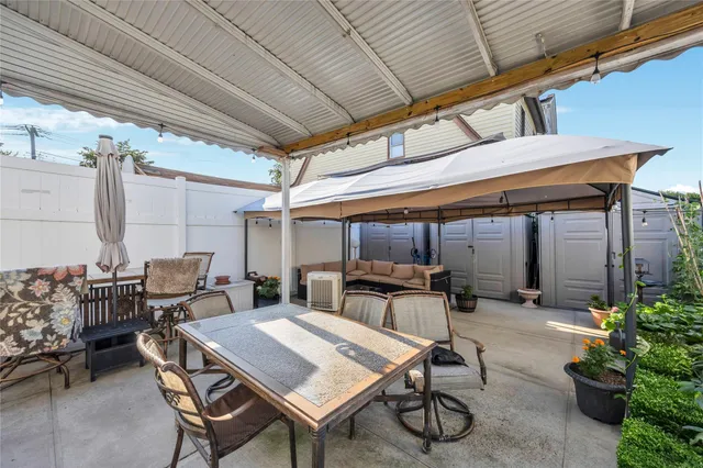 a patio with table and chairs with potted plants