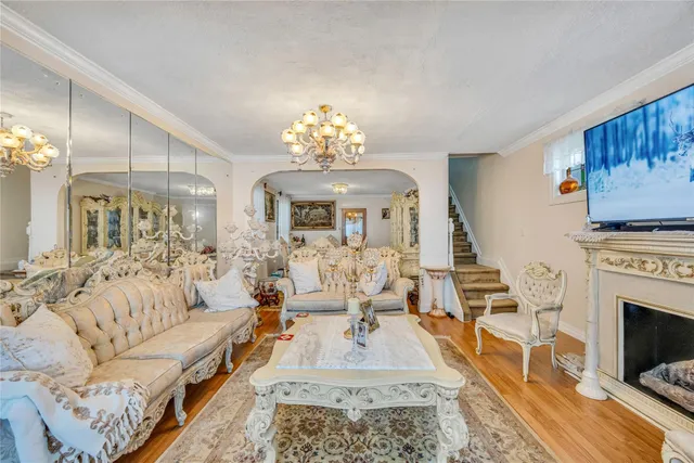 a living room with furniture a chandelier and a fireplace