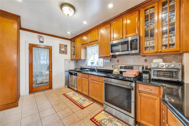 a kitchen with stainless steel appliances granite countertop a refrigerator and a stove top oven