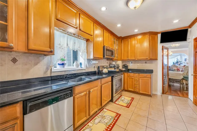 a kitchen with stainless steel appliances granite countertop a stove a sink and a microwave
