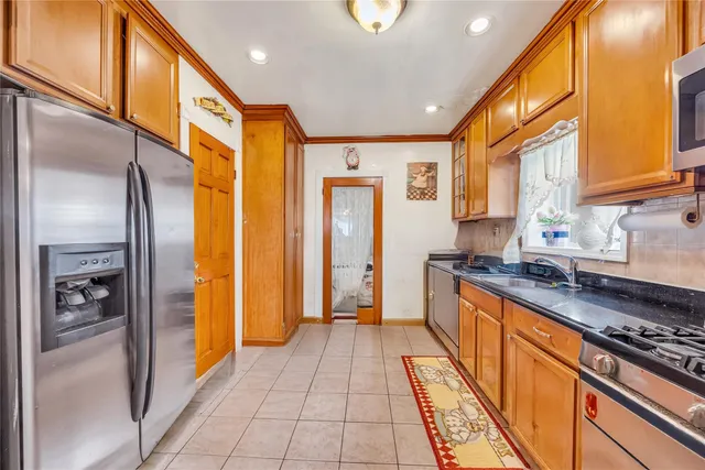 a large kitchen with stainless steel appliances granite countertop a refrigerator and a stove