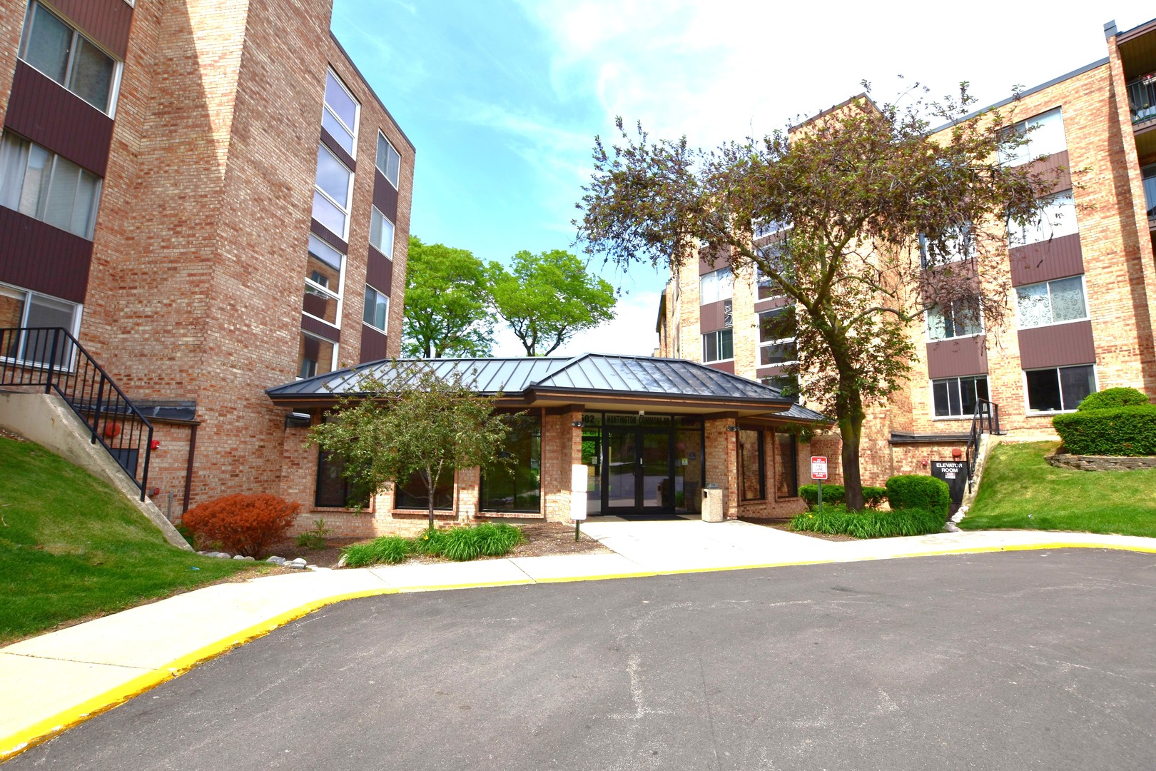 500 West Huntington Commons Road, Unit 157 Mount Prospect, IL 60056 - Photo 1 of 24 a front view of a building with a garden